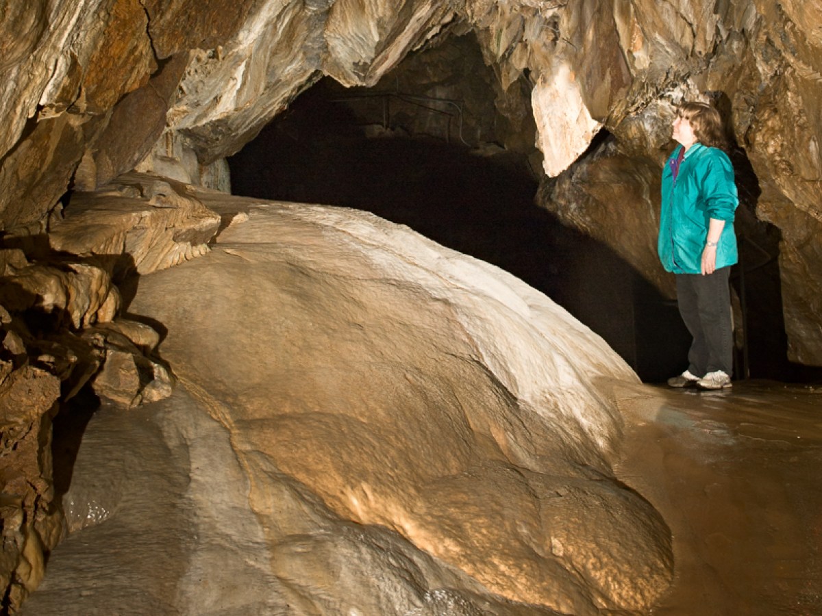a person riding on the back of a cave
